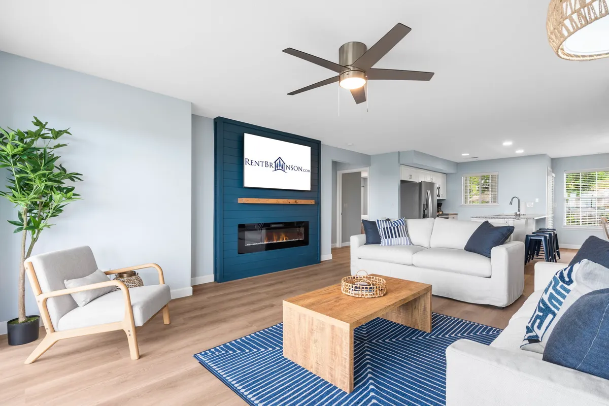 This image presents a cozy living room with a comfortable sofa and coffee table, a TV set perfectly for movie night, a welcoming fireplace, and a touch of greenery from a plant, all bathed in inviting light. The arrangement emphasizes both relaxation and opportunities for connection.